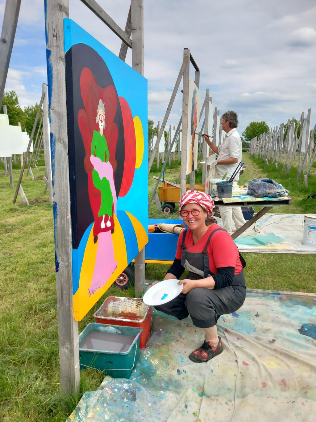 Portrait von Utra Strack, hockend vor ihrer unfertigen grossformatigen Malerei während der Colourfield Performance in Elst